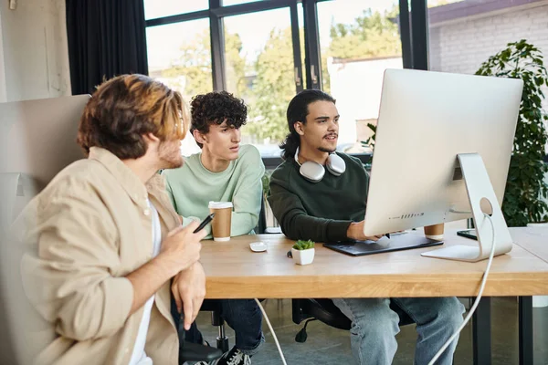 Creative team intensely focused on post-production work in a modern office, men in 20s — Stock Photo
