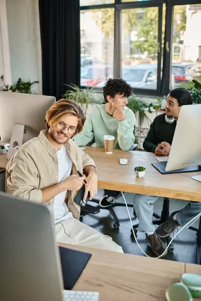 Счастливый творческий коллектив интенсивно сосредоточен на пост-продакшн работе в современном офисе, мужчинам 20 лет — стоковое фото
