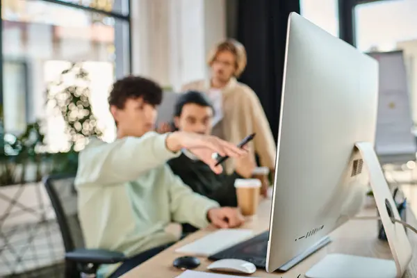 Post production team of young men discussing retouching project in office, focus on monitor — Stock Photo
