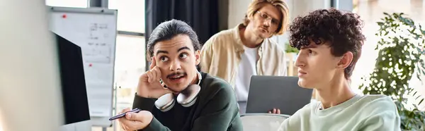 Пост-продакшн ретушь команда обсуждает проект на мониторе в современном офисе, мужчины в 20-х баннер — стоковое фото