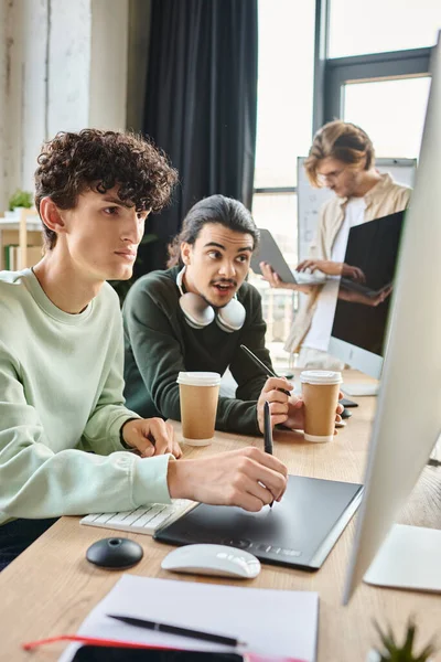 Post production retouching professionals discussing project on monitor in modern office, men in 20s — Stock Photo