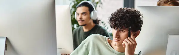 Uomo riccio concentrato impegnato nel lavoro di ritocco con penna stilo in mano guardando monitor, banner — Foto stock