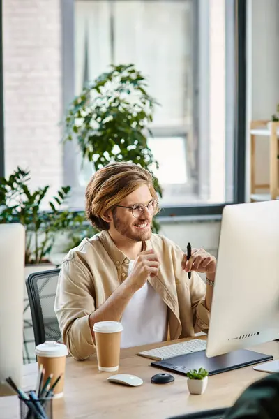 Profissional masculino alegre em óculos olhando monitor perto de café e tablet gráfico na mesa — Fotografia de Stock