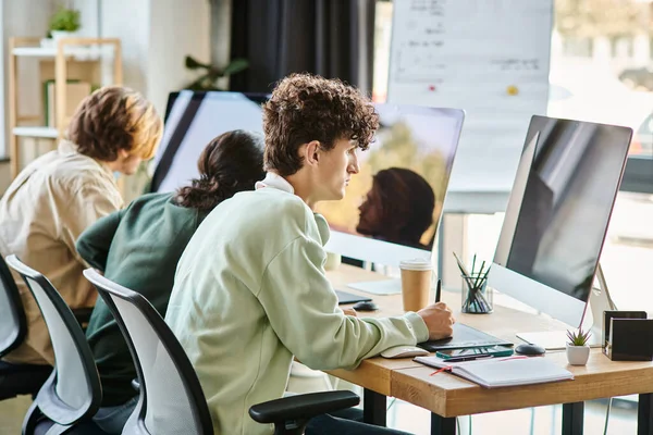 Giovane uomo dai capelli ricci modifica le foto su tablet e guardando il monitor nell'area di lavoro dell'ufficio di avvio — Foto stock