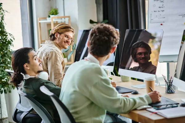 Пост-продакшн команда обсуждает проект возле гаджетов для ретуширования в офисе, веселые мужчины в 20 лет — стоковое фото