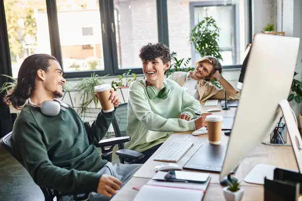 Молодые профессионалы смеются вместе во время кофе-брейка в офисе стартапа, после съемочной группы — стоковое фото
