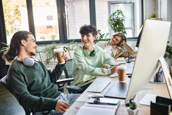 Jeunes professionnels riant ensemble pendant la pause café dans un bureau de démarrage, équipe de post-production — Photo de stock