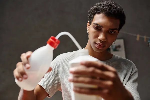 Dark skinned photographer preparing film development solution in darkroom, analog photography — Stock Photo