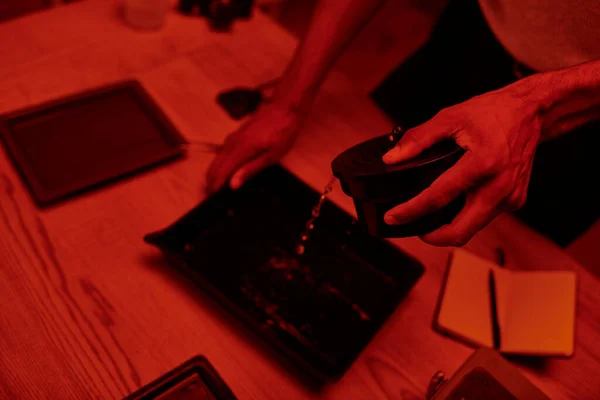 Overhead-Ansicht des Fotografen gießt Entwickler in Tablett zur Filmbearbeitung in roter Dunkelkammer — Stockfoto