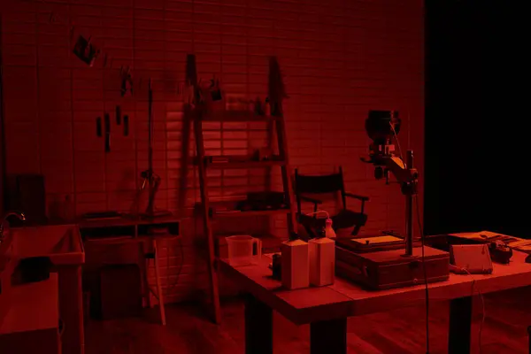 Інтер'єр темної кімнати з хімічними пляшками та інструментами, що демонструють процес розробки плівки — стокове фото