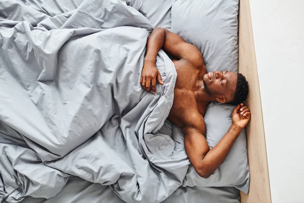 Blick von oben auf hübsche athletische afrikanisch-amerikanische Mann schlafen auf bequemen Bett zu Hause in der Früh — Stockfoto