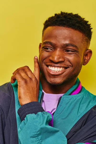 Porträt eines fröhlichen schwarzen Mannes in stylischer Freizeitkleidung, der mit dem Finger auf Gelb zeigt — Stockfoto