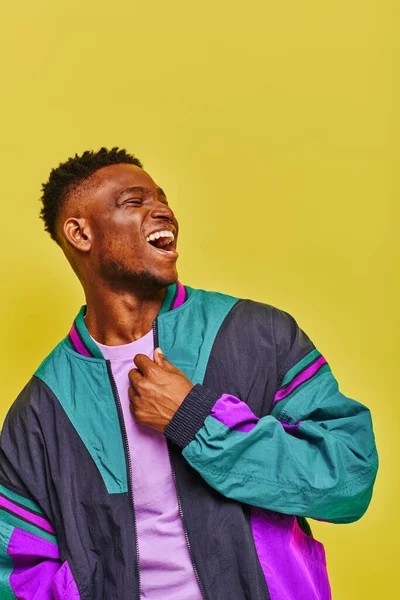 Emotivo afroamericano uomo in abbigliamento casual alla moda ridendo e guardando lontano sul giallo — Foto stock
