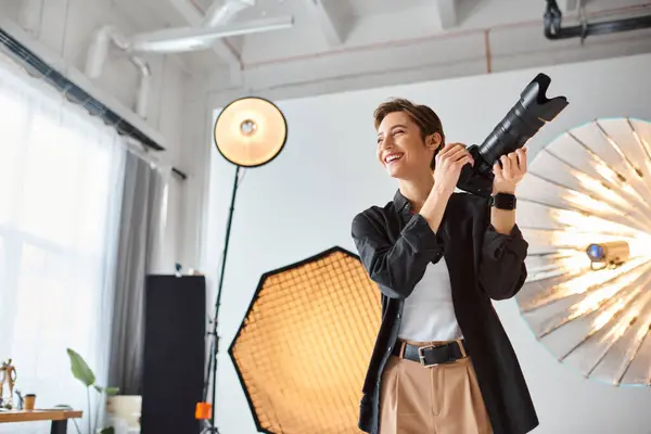Joyous female photographer in casual attire with camera in her hands smiling and looking away — Stock Photo