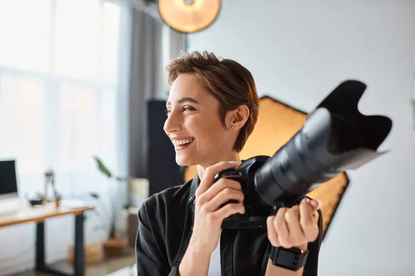 Jolly female photographer in casual attire with camera in her hands smiling and looking away — Stock Photo