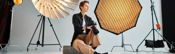 Bela jovem fotógrafa em roupas casuais posando em seu estúdio e olhando para longe, banner — Fotografia de Stock