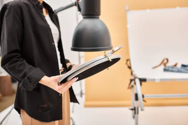 Cropped view of young female photographer in casual clothing working at studio with her equipment — Stock Photo