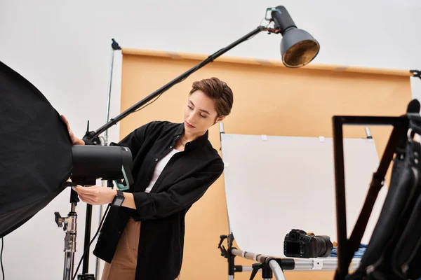 Attractive young female photographer in everyday clothing working with her equipment at studio — Stock Photo