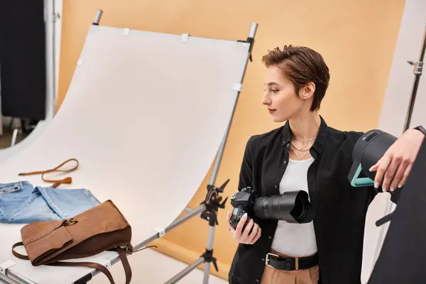 Beautiful brunette female photographer in everyday clothing working with her equipment at studio — Stock Photo