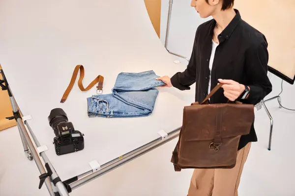 Приваблива молода жінка-фотограф готується робити фотографії джинсів і коричневого рюкзака — стокове фото