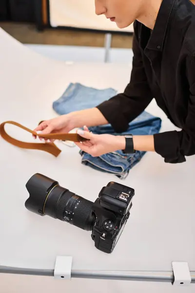 Cropped view of young talented female photographer preparing to make object photos of denim — Stock Photo
