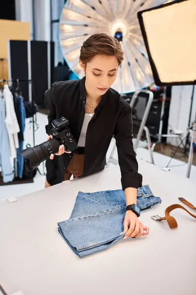 Beautiful focused female photographer holding camera and preparing to take photos in her studio — Stock Photo