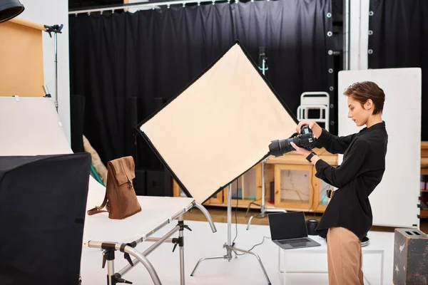 Beautiful talented female photographer taking photos of brown leathered backpack in her studio — Stock Photo