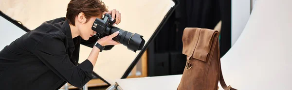 Fotógrafa bonita tirando fotos de mochila de couro marrom em seu estúdio, banner — Fotografia de Stock
