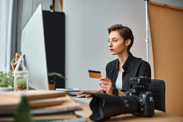 Beautiful young female photographer in casual comfy attire paying online with her credit card — Stock Photo