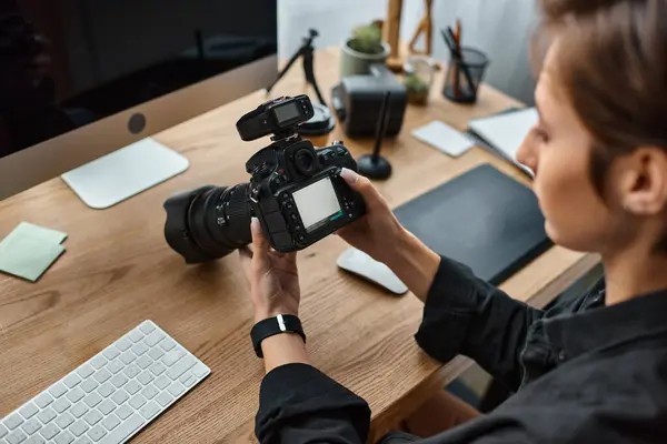 Focus on camera in hands on blurred profeessional female photographer working on her photos — Stock Photo