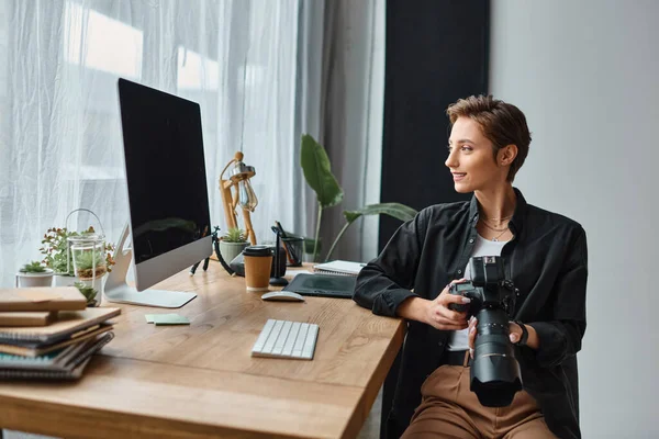Alegre atraente fotógrafo feminino em traje casual trabalhando duro em suas fotos em estúdio — Fotografia de Stock