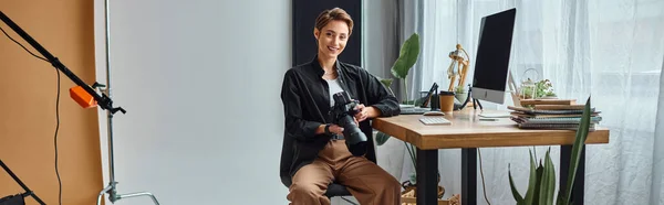 Alegre fotógrafa bonita sorrir para a câmera enquanto trabalhava em suas fotos em estúdio, banner — Fotografia de Stock
