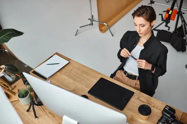 Good looking short haired female designer in casual attire working on her project on drawing tablet — Stock Photo