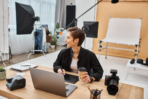 Cheerful professional female designer in casual attire working with her drawing tablet in studio — Stock Photo