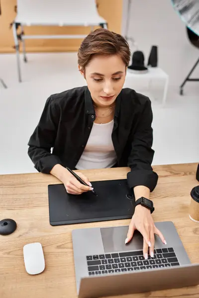 Beautiful professional female designer in casual attire working with her drawing tablet in studio — Stock Photo
