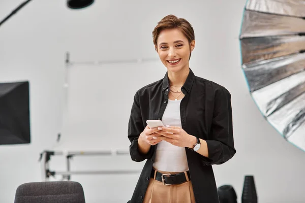 Merry female photographer making stories for social media in her studio and looking at camera — Stock Photo