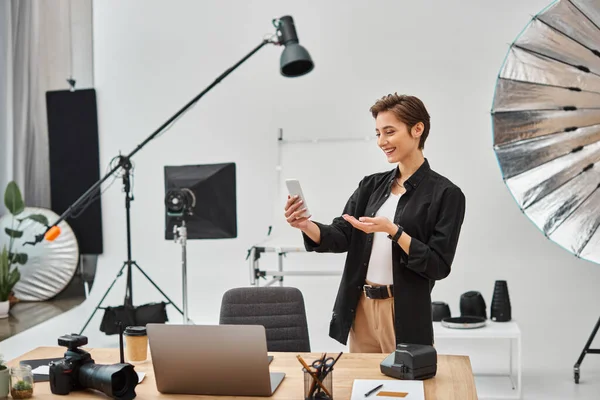 Cheerful female photographer in casual attire making stories for her social media in her studio — Stock Photo
