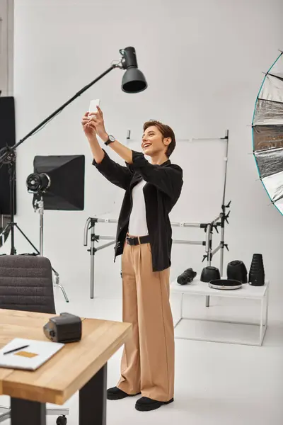 Joyous young female photographer with short hair making stories for her social media in her studio — Stock Photo