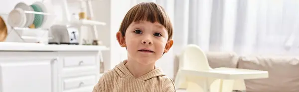 Adorable toddler boy in comfy homewear looking at camera during breakfast on kitchen, banner — Stock Photo