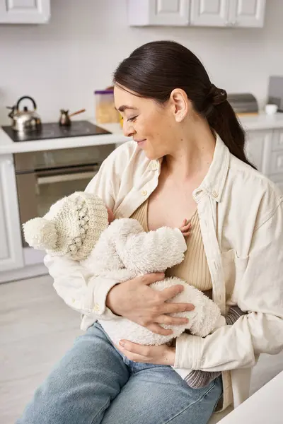 Beautiful happy woman in cozy homewear posing with her cute newborn baby boy, modern parenting — Stock Photo