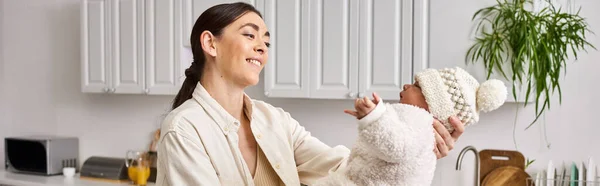 Pretty jolly woman in cozy homewear posing with her cute newborn baby boy, modern parenting, banner — Stock Photo