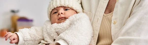 Lindo bebé recién nacido en traje cálido y acogedor en manos de su madre cariñosa, crianza moderna, pancarta - foto de stock