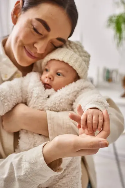 Attraktive liebevolle Mutter in bequemer Hauskleidung, die ihren kleinen Jungen warm hält, moderne Elternschaft — Stockfoto