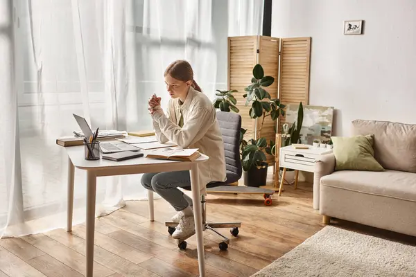 Focused teenage girl looking at laptop while doing her homework, distance learning concept — Stock Photo
