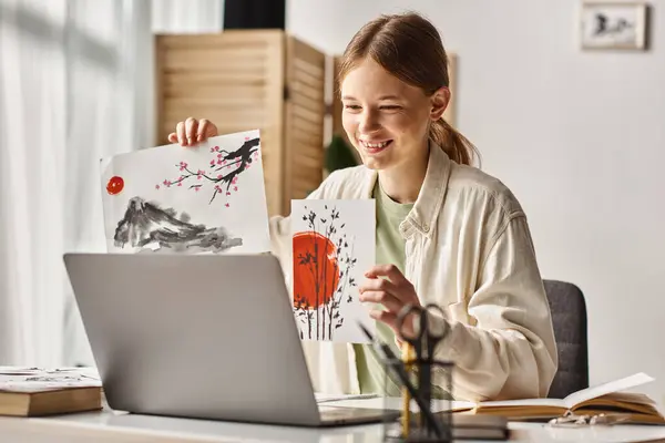 Happy teenager girl showing her artwork while studying and looking at her laptop, art class online — Stock Photo