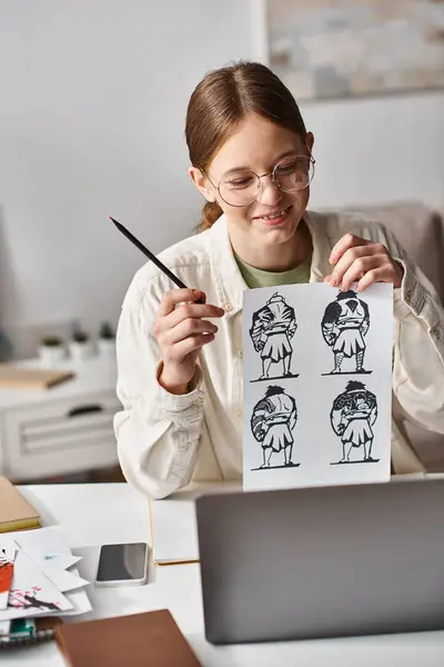 Teenage girl analyzing anatomy drawings for e-learning art class at home, looking at laptop — Stock Photo