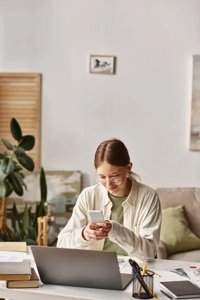 Menina adolescente feliz usando smartphone perto de laptop perto de seu desenho esboço na mesa, aula de arte on-line — Fotografia de Stock