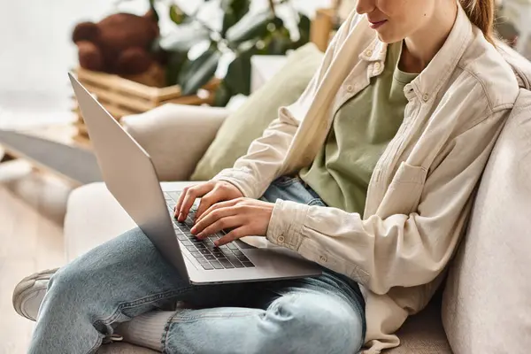 Zugeschnittenes Teenager-Mädchen, das sich auf E-Learning mit Laptop konzentriert und zu Hause auf einem bequemen Sofa sitzt — Stockfoto