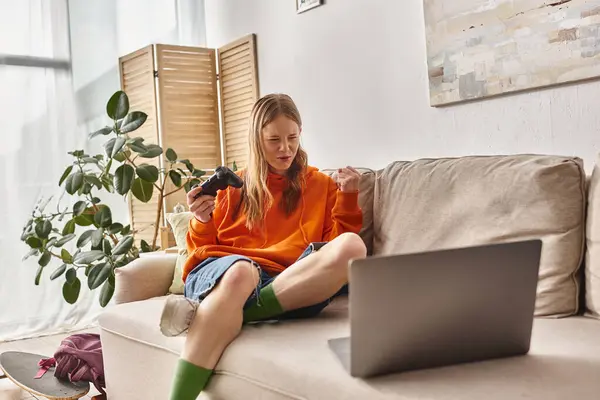 Adolescent émotionnel fille avec joystick et portable jeu gagnant et assis sur le canapé à la maison, week-end vibes — Photo de stock