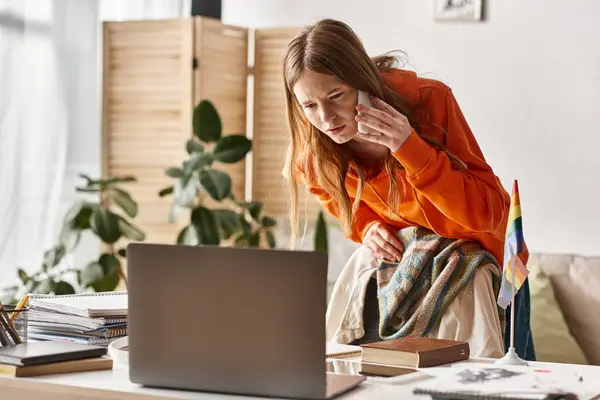 Centrado chica adolescente estudiando en línea en casa, haciendo una llamada al lado de orgullo lgbtq bandera en el escritorio - foto de stock